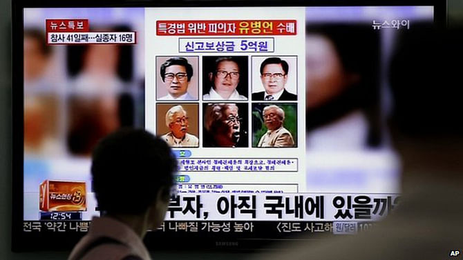 A woman looks at a 'wanted' poster for Yoo Byung-eun, shown on a South Korean TV news channel - 26 May 2014 A nationwide manhunt for ferry company owner Yoo Byung-eun was launched after the disaster