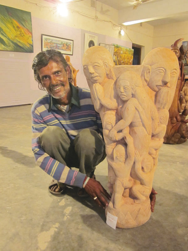 A participating artist at the SM Sultan Utsob 2014 poses with his Christianity inspired sculpture. Photo: Andrew Eagle