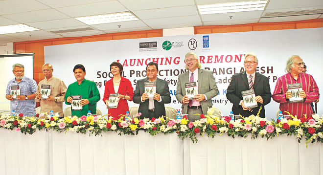 Planning Minister AHM Mustafa Kamal joins others at the launch of a book titled "Social Protection in Bangladesh: Building Effective Social Safety Nets and Ladders out of Poverty" at Bangabandhu International Conference Centre in Dhaka yesterday. Photo: Star