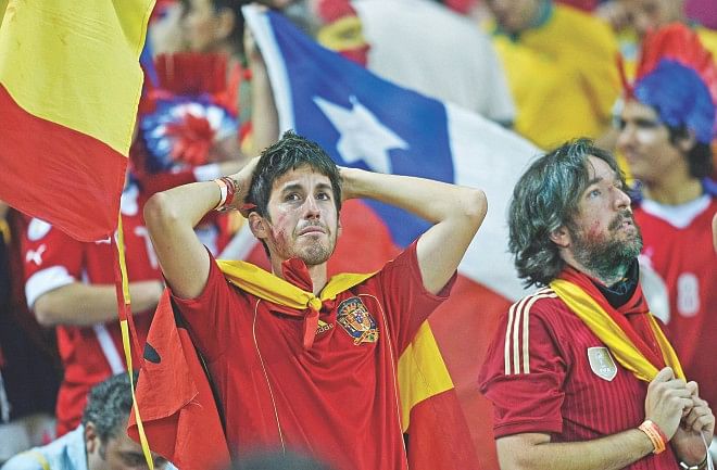 Disconsolate Spanish fans reflect after their team relinquished the World Cup with a 2-0 defeat to Chile in a Group B match at the Maracana Stadium in Rio de Janeiro on Wednesday. PHOTO: AFP