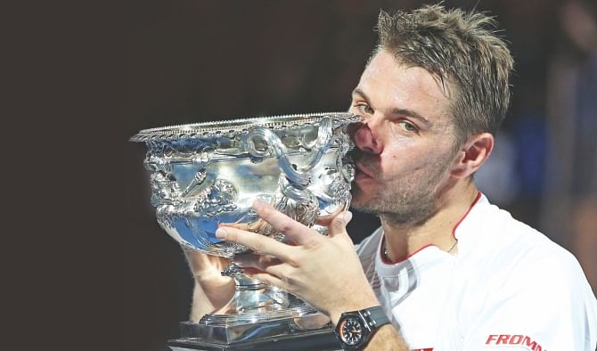 Stanislas Wawrinka kisses the Australian Open trophy after upsetting Rafael Nadal.