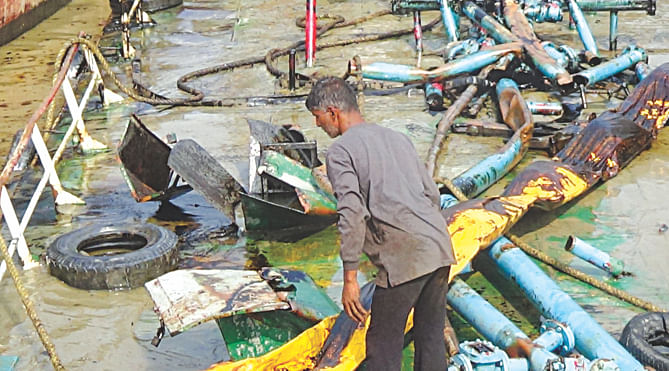 A man inspecting the wreck of the oil tanker after it was pulled out of the Shela river yesterday. The tanker went down in the river loaded with furnace oil early Tuesday causing damage to the environment of the Sundarbans, the largest of its kind in the world.  Photo: Star