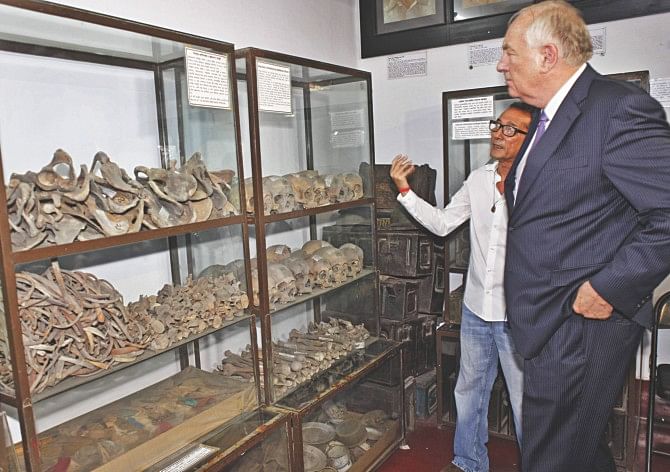Stephen J Rapp, US ambassador-at-large for war crimes issues, looks at the remains of some of the country's martyrs at Liberation War Museum in the capital yesterday, accompanied by Akku Chowdhury, a freedom fighter also a trustee of the museum. Photo: Star