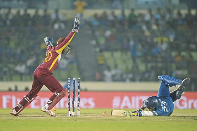 West Indies fielding was absolutely brilliant in the first ICC World T20 semifinal against Sri Lanka at Mirpur yesterday. Here a diving Tillakaratne Dilshan is still short of his ground as a direct hit from Lendl Simmons dislodges the LED bails.  Photo: AFP