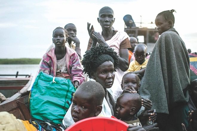 People arrive at Minkammen, a small South Sudan port yesterday, fleeing violence in Bor region. South Sudan's young democracy risks "shattering" amid fierce fighting which has cost over 1,000 lives, a top US official warned yesterday. Photo: AFP