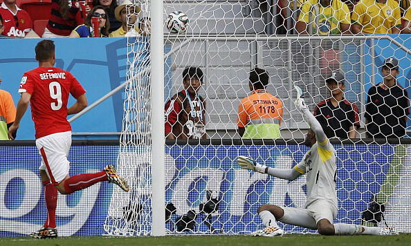 Switzerland's forward Haris Seferovic (L) scores past Ecuador's goalkeeper Alexander Dominguez during a Group E football match between Switzerland and Ecuador at the Mane Garrincha National Stadium in Brasilia during the 2014 FIFA World Cup on June 15, 2014. Photo: AFP/Getty Images