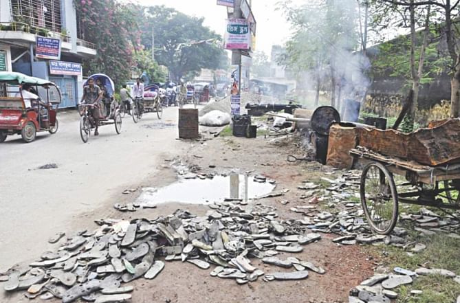 Smoke from burning discarded synthetic sandals, used as fuel for melting bitumen, poses serious health risk for pedestrians and commuters. The photo was taken from Paharpur in Dinajpur town on Monday.   PHOTO: STAR