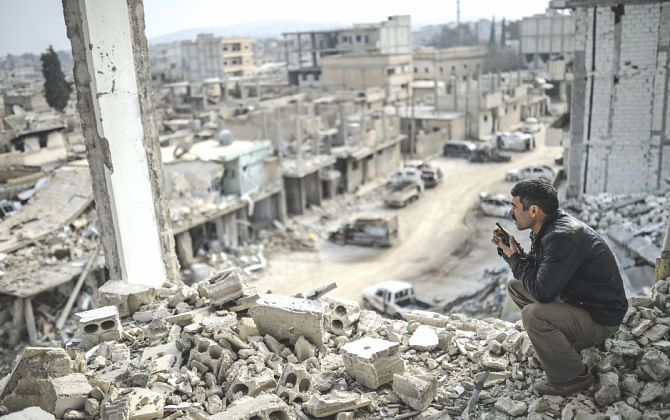 A man looks at the war-ravaged town from a destroyed building. Kurds recaptured the strategic town on January 26 in a symbolic blow for the jihadists. Photo: AFP