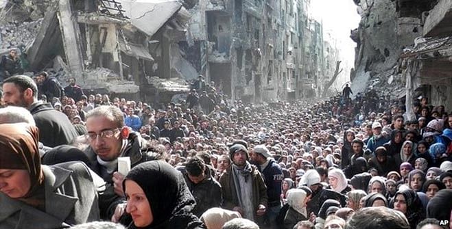 A vast crowd of people queue for aid at the Yarmouk refugee camp near Damascus