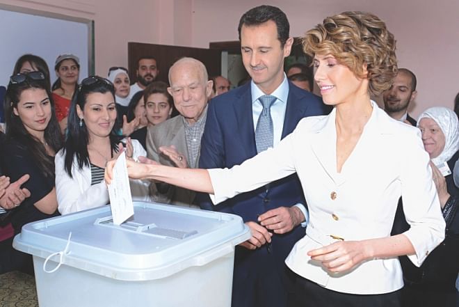 Syrian President Bashar al-Assad (C) watching on as his wife Asma casts her vote at a polling station in central Damascus.  Photo: AFP