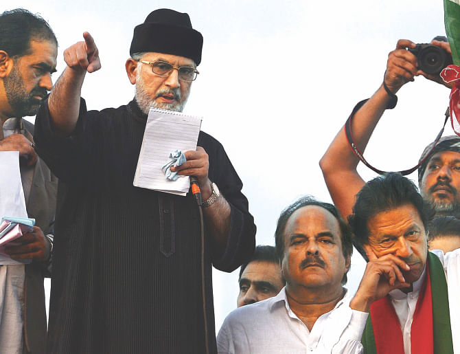 Pakistani protest leader Imran Khan, right, listens as protest leader Tahir-ul-Qadri addresses supporters during the anti-government march in Islamabad yesterday. Pakistan's interior minister slammed violent anti-government protests as a 