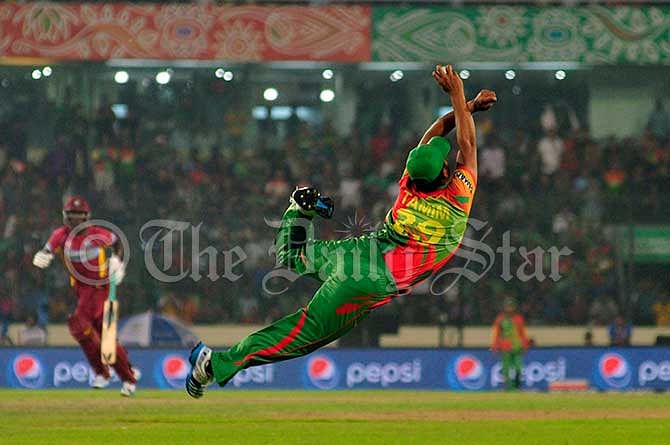 Tamim Iqbal takes an outstanding catch of Dwayne Bravo off Al-Amin Hossains delivery during a match between Bangladesh and West Indies at Mirpur Stadium today. Photo: Firoz Ahmed