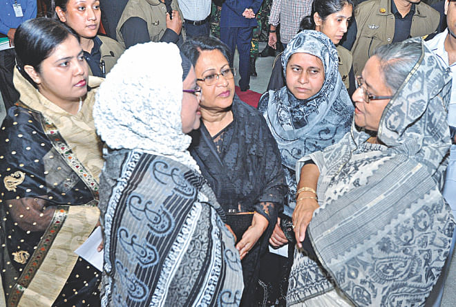 Prime Minister Sheikh Hasina talks with family members of the army officers, killed in the 2009 BDR massacre, after handing them over cheques as financial assistance from Bangladesh Association of Banks at her office yesterday. The assistance is given annually in cooperation with the Prime Minister's Office.  Photo: BSS