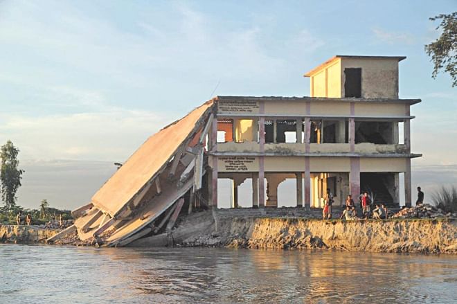 The Teesta devours part of a two-storey Dhusmara Government Primary School in Kaunia upazila of Rangpur district as erosion by the river has taken an alarming turn in the area. Photo: Star