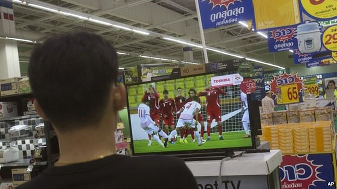 A Thai shopper watches a soccer match on a flat-panel television at a shopping mall in Bangkok, Thailand Wednesday, June 11 Football is extremely popular in Thailand