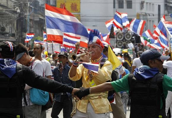 An anti-government protester blows a trumpet during a rally in central Bangkok March 28, 2014.  Photo: AP
