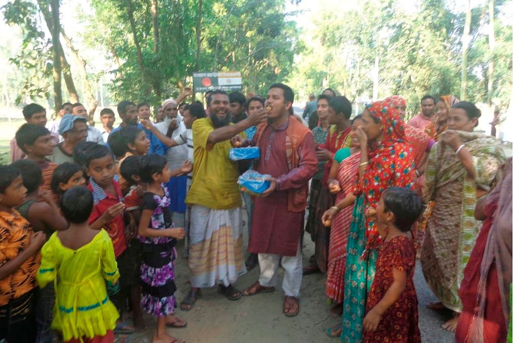 People of Puthimari Indian enclave in Boda upazila of Panchagarh are all smiles while distributing sweetmeat on Friday on hearing that Paschimbanga chief minister Mamata Banergee had finally wanted to resolve the enclave issue in near future. PHOTO:STAR