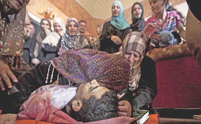 The mother and sister of Palestinian Mahmud al-Sewati mourn over his body during his funeral in Gaza City, yesterday.  Photo:AFP
