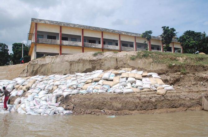 Arambaria High School and adjoining Arambaria Primary School in Ishwardi upazila under Pabna district face extinction due to erosion by the Padma River that has already devoured two other buildings and most of the ground of the high school. PHOTO: STAR