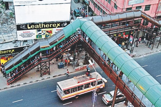 This footbridge over Kazi Nazrul Islam Avenue is now getting a rather dark and dreary brown over its eye-soothing green coat of paint as part of a “beautification” project ahead of the T20 world cup.  Photo: Anisur Rahman/File