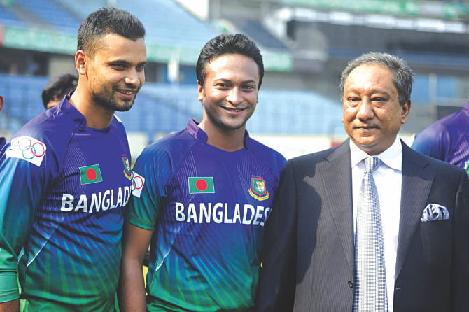 Captain Mashrafe Bin Mortaza (L) and Shakib Al Hasan (C) show their newly-designed Asian Games cricket jersey as they stand alongside BCB president Nazmul Hassan Papon at Mirpur yesterday. Photo: Star