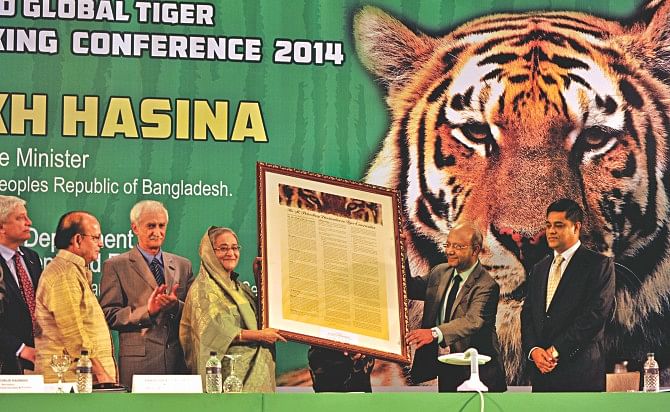 Prime Minister Sheikh Hasina hands over a plaque during the inaugural ceremony of the Second Global Tiger Stocktaking Conference 2014 at Sonargaon Hotel yesterday.  Photo: BSS