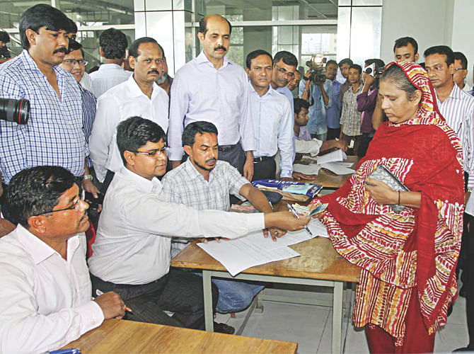 A worker of Tuba Group receives partial payments of their dues at Bangladesh Garment Manufacturers and Exporters Association's office in Dhaka yesterday. Photo: Bangla Chokh 