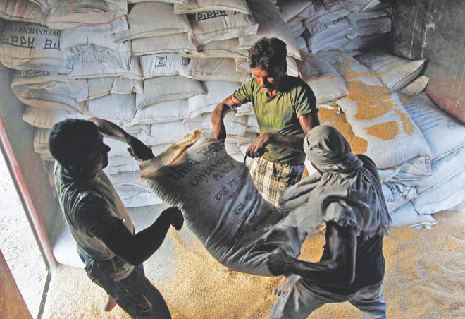 Labourers unload sacks of wheat from a goods train at a railway yard in the northern Indian city of Allahabad. Photo: Reuters