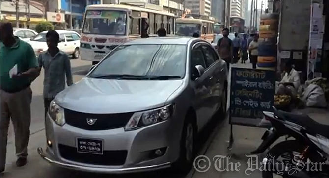 A private car, parked on the pavement at Kazi Nazrul Islam Avenue in Dhaka, compels pedestrians to use the main road to walk by. Photo: SAM Jahan