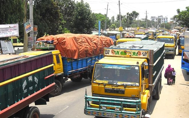 Vehicles lie stranded on Thakurgaon-Dhaka highway in Thakurgaon yesterday as transport workers block the road, demanding release of eight fellow workers. Photo: Star