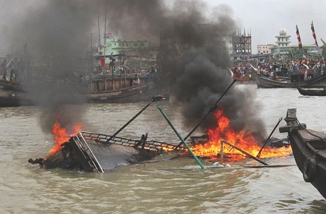 A trawler begins to sink after it caught fire when its engine exploded killing two fishermen and injuring four others in the Karnaphuli river in Chittagong city's Fishery Ghat area yesterday.    Photo: Star