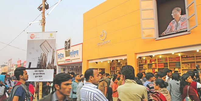 A giant cut-out of Humayun looks on as his fans throng the Ekushey Book fair. 