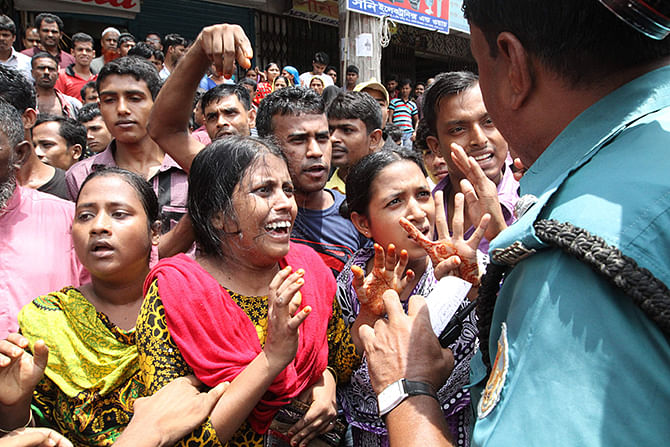 Agitating workers of Tuba Group hold demonstration while law enforcers try to resist them in the capital’s Badda on Thursday. Photo: Amran Hossain. 