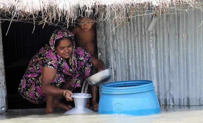 A woman of the same area using rainwater as tube wells in at least 13 villages in the upazila went under saline water last month. Photo: Star