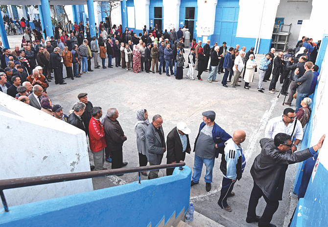 Tunisian wait to cast their vote at a polling station in the center of Tunis yesterday, during Tunisia's first presidential election since the 2011 revolution.  Photo: AFP