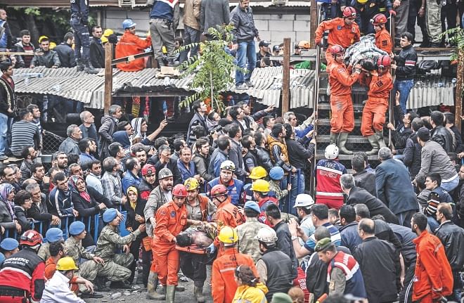 Tragedy a mile underground:  Rescuers carry out dead miners yesterday after an explosion and fire in a coal mine in the western Turkish province of Manisa killed at least 245 people and 120 remain trapped underground.  Photo: AFP