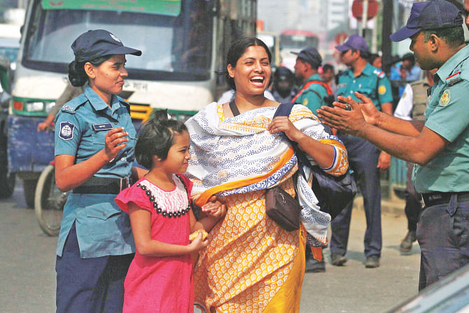 Two cops talking to a mother after she had jaywalked on Kazi Nazrul Islam Avenue with her child. A crackdown on jaywalking began on the avenue yesterday, and 331 pedestrians were fined on the first day.  Photo: Anisur Rahman