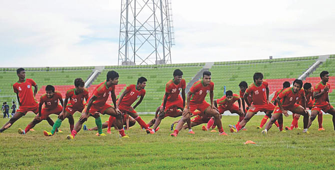 Bangladesh U-23 booters stretch during a practice session at the Sylhet Cricket Stadium yesterday. PHOTO: STAR