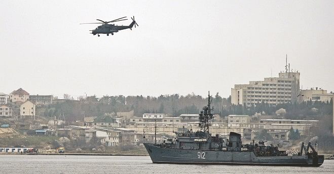 A Russian Mi24 military helicopter flies over the Russian navy minesweeper ship 