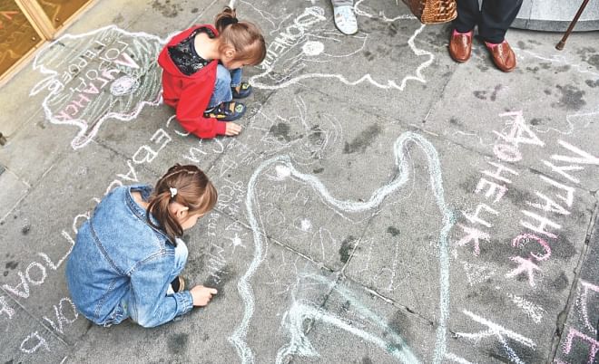 Refugee children draw symbolic maps depicting their regions and cities, on the sidewalk at the entrance of the parliament during the rally. At least 10,000 people have been driven from their homes since the start of the Ukraine crisis, with Crimean Tatars the hardest-hit, according to the UN. Photo: AFP
