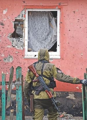 A pro-Russian fighter visits a house yesterday after it was damaged by shelling the day before in Makiivka, in the suburbs of the eastern Ukrainian city of Donetsk. Photo: AFP