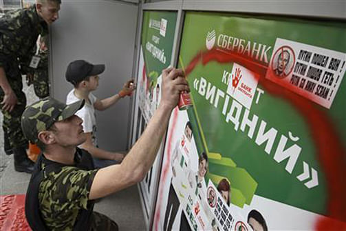 Members of Ukrainian self-defence units vandalise an office of Sberbank of Russia during a rally in Kiev, March 26. Photo: Reuters 