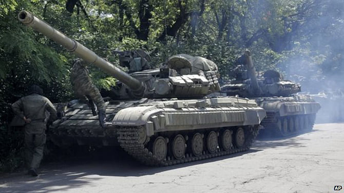 Pro-Russian troops prepare to travel in a tank on a road near the town of Yanakiyevo, Donetsk region, eastern Ukraine, Friday, June 20, 2014. Pro-Russian sentiment in strong in eastern Ukraine