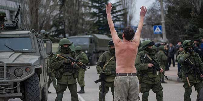 A Ukrainian man stands in protest in front of gunmen in unmarked uniforms as they stand guard in Balaklava, on the outskirts of Sevastopol, Ukraine, Saturday, March 1. Photo: AP 