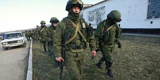 Military personnel, believed to be Russian servicemen, walk outside the territory of a Ukrainian military unit in the village of Perevalnoye outside Simferopol March 3. Photo: Reuters
