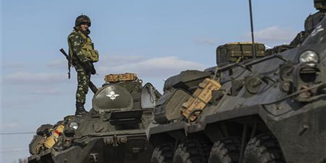 A Ukrainian soldier stands on top of an armoured personnel carrier at a checkpoint near the village of Salkovo in Kherson region adjacent to Crimea, March 18. Photo: Reuters 