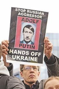 An anti-war demonstrator holds a sign depicting Russian President Vladimir Putin as World War II Nazi German dictator Adolf Hitler as he takes part in a protest against Russian intervention in Ukraine, on the sidelines of a EU Foreign Affairs Ministers meeting dedicated to the situation in Ukraine at the EU Council building in Brussels, yesterday.  Photo:AFP