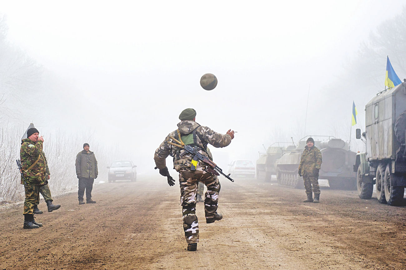 Ukrainian servicemen play football on a road at Svitlodarsk, approaching Debaltseve, yesterday. Photo: AFP