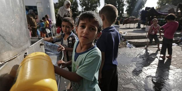 Displaced Palestinian children collect water at the Abu Hussein UN school, in Jebaliya refugee camp, northern Gaza Strip, 30 July 2014 The UN school hit on Wednesday was sheltering more than 3,000 displaced Palestinians. Photo: AP