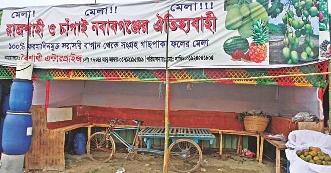 This makeshift fruit stall in Rampura shuts down yesterday from fear that mobile courts will penalize it for selling chemical tainted fruits. The banner still touts its mangoes from Rajshahi and Chapainawabganj as being 100 percent formalin free. Photo: Anisur Rahman